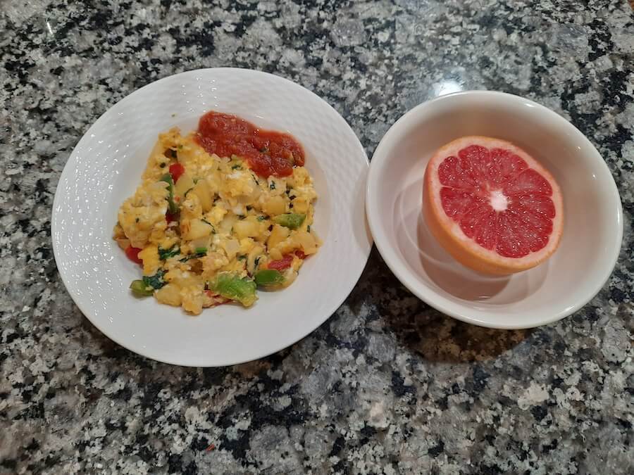 second nature - skillet with chicken breast, spinach, onions, peppers, and sweet potato with a half of grapefruit